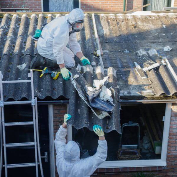 Licensed asbestos removal with full PPE and containment barriers